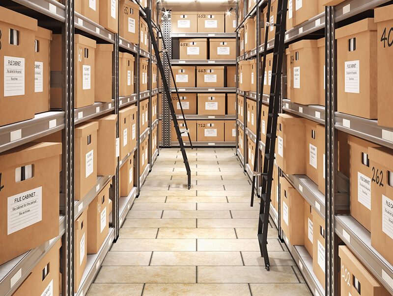 Multiple cardboard boxes containing documents systematically organized on sturdy metal shelves, contributing to an efficient and structured storage system. The image reflects a well-managed document management setup, ensuring accessibility and orderliness.